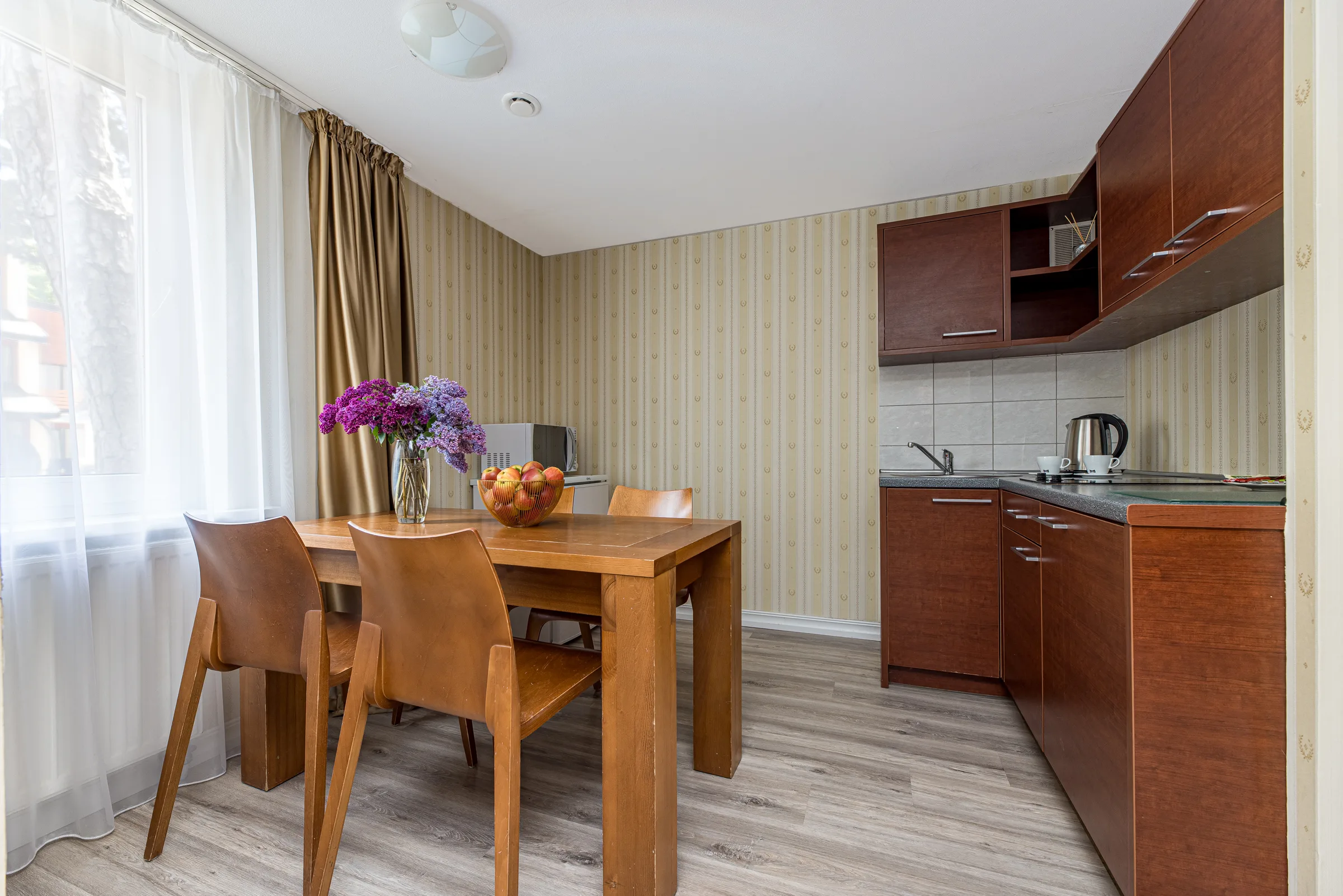 Kitchen with a dining table and a bunch of lilacs