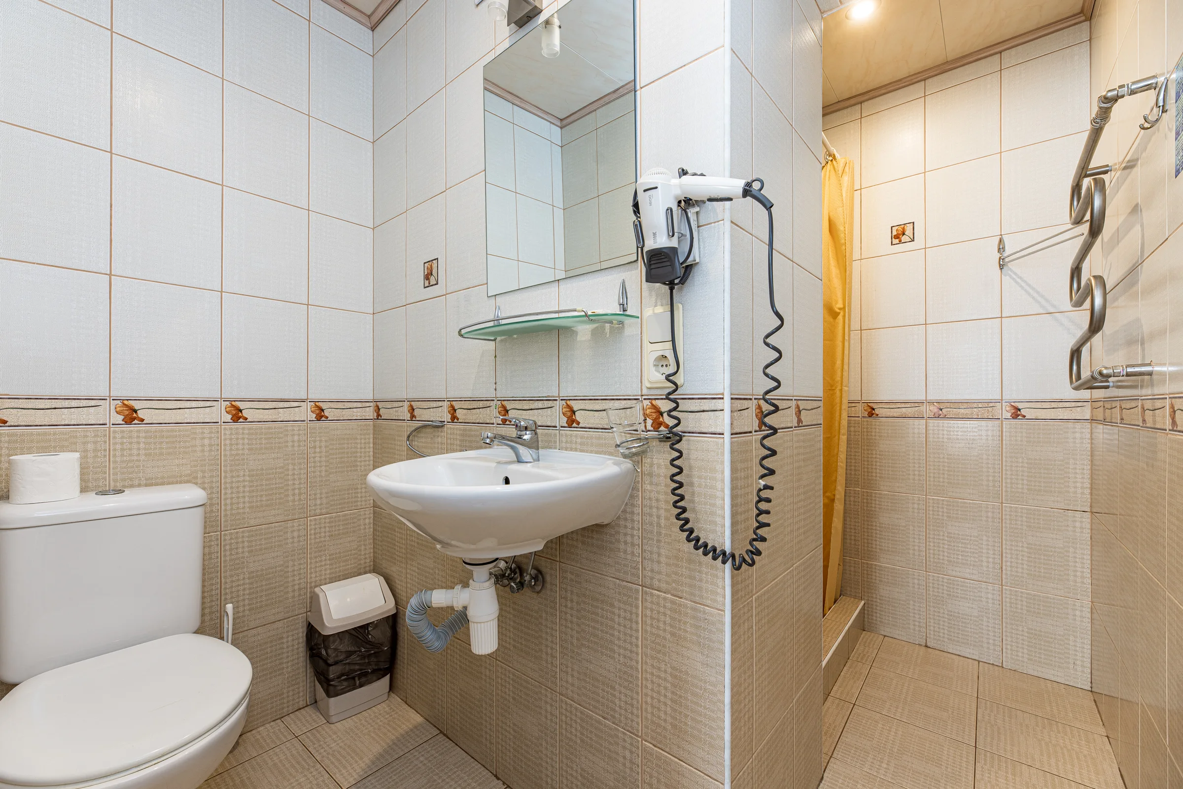 Bathroom with a shower, washbasin, mirror and hairdryer