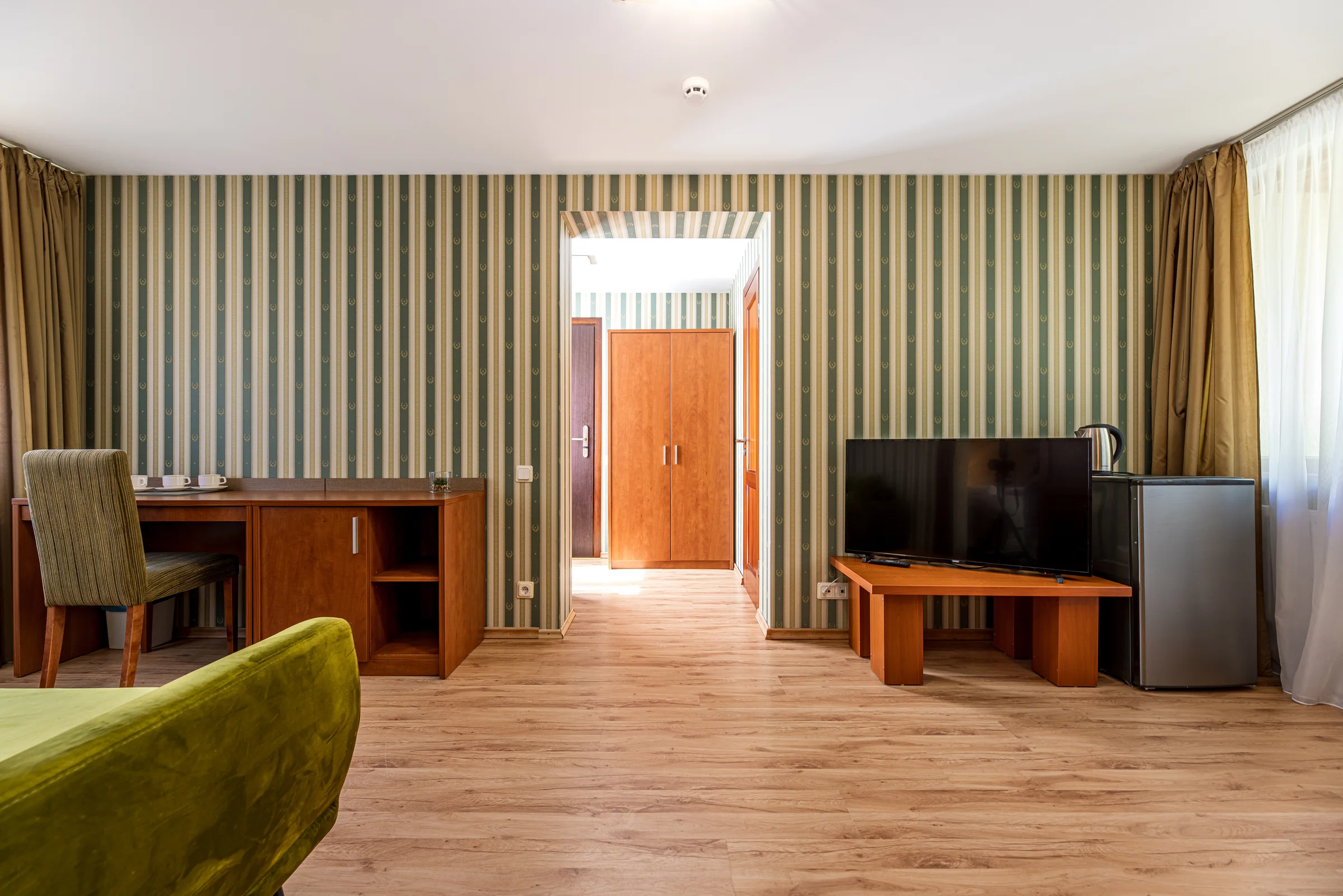 Family room living area: green sofa, desk and TV