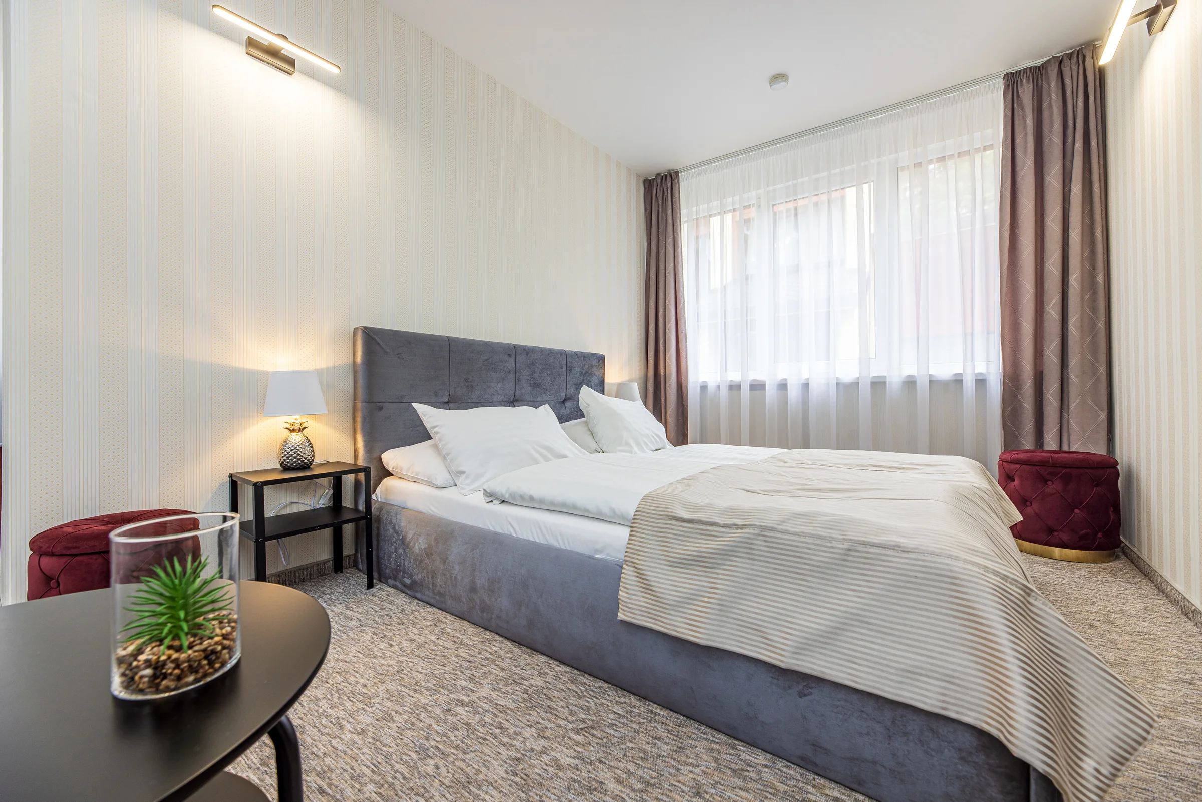 Superior double: double bed with a grey headboard and a round table