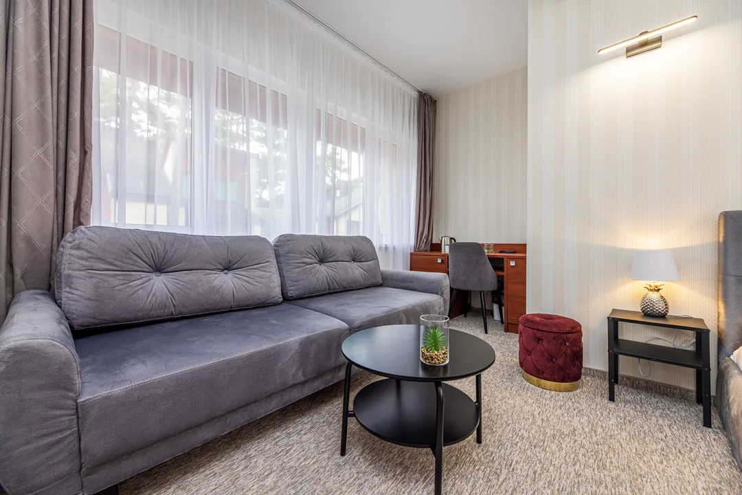 Grey sofa with a round coffee table and a desk with chair by the window