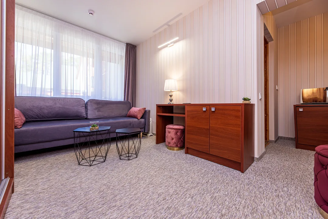 Living room with a grey sofa, two coffee tables and a wooden chest of drawers