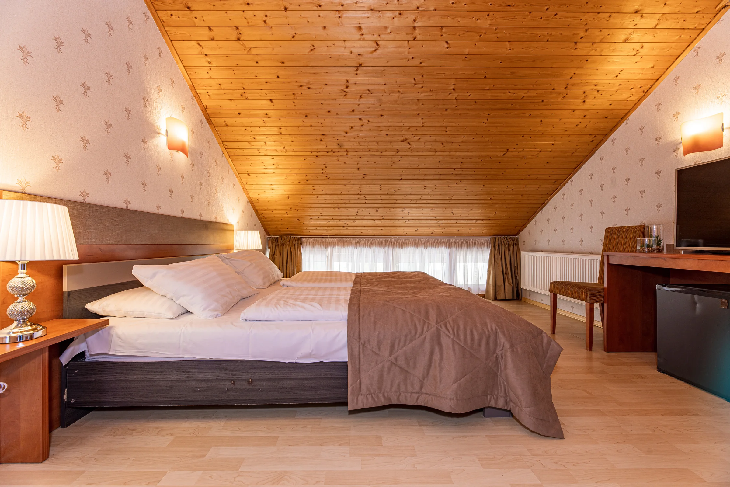 Double room with balcony: double bed under a pine-board ceiling